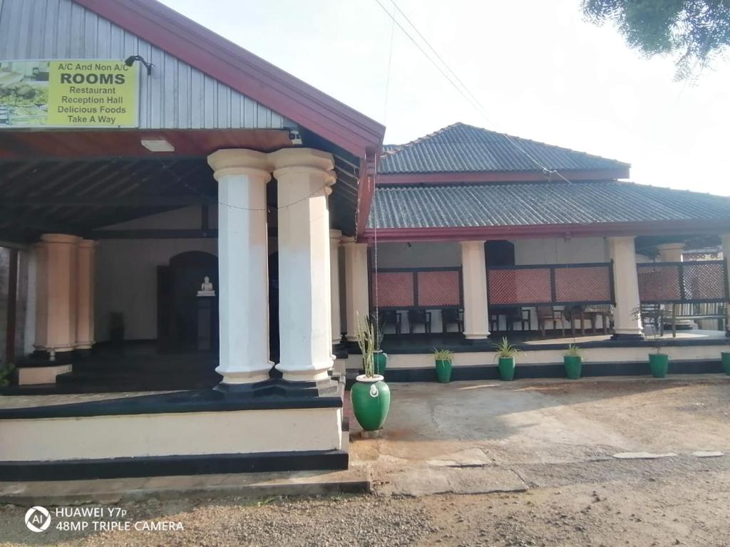 ein Gebäude mit zwei weißen Säulen und einem Gebäude in der Unterkunft Walawwa resort in Kurunegala