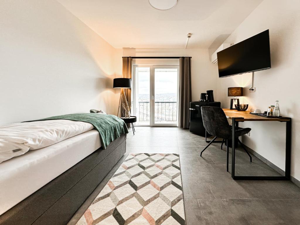 - une chambre avec un lit et un bureau avec une télévision dans l'établissement SI-View Einzelzimmer mit Balkon Zimmer 4, à Siegen