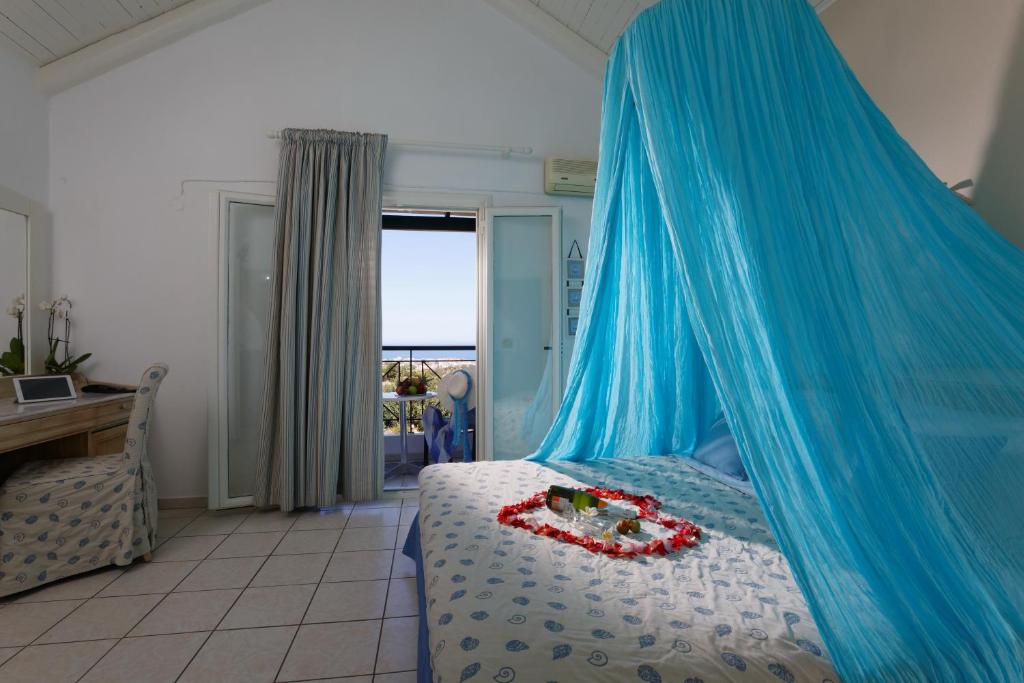 a bedroom with a bed with a blue mosquito net at Piskopiano Village in Hersonissos