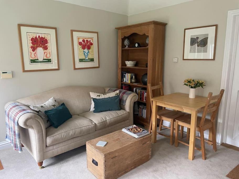 sala de estar con sofá y mesa en Cosy Country Cottage, en Bethersden