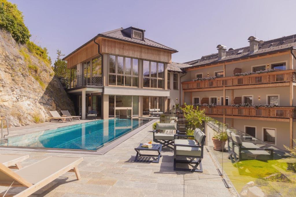 una casa con piscina al lado de un edificio en Hotel Weissenstein, en Sankt Michael im Lungau