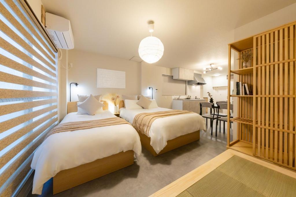 two beds in a room with a kitchen at City Hotel Osaka Retreat in Osaka