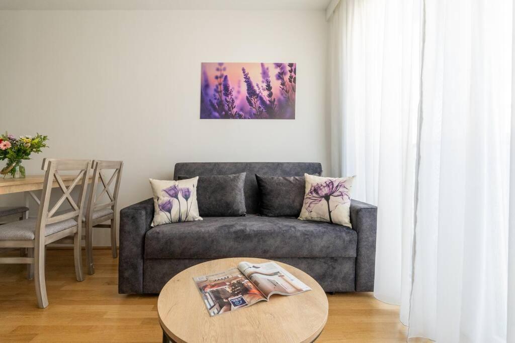 ein Wohnzimmer mit einem Sofa und einem Tisch in der Unterkunft HM • Stylish 1BR Escape, City Quick in Wien
