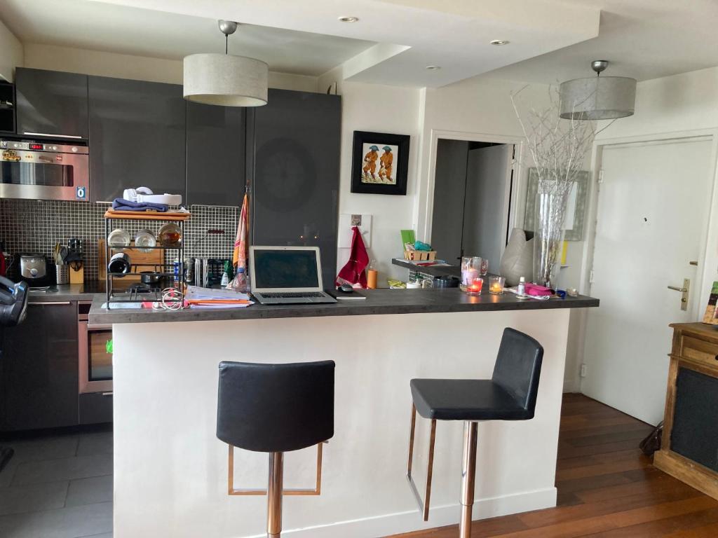 - une cuisine avec un comptoir et un ordinateur portable dans l'établissement Spécial jeux olympiques, à Levallois-Perret