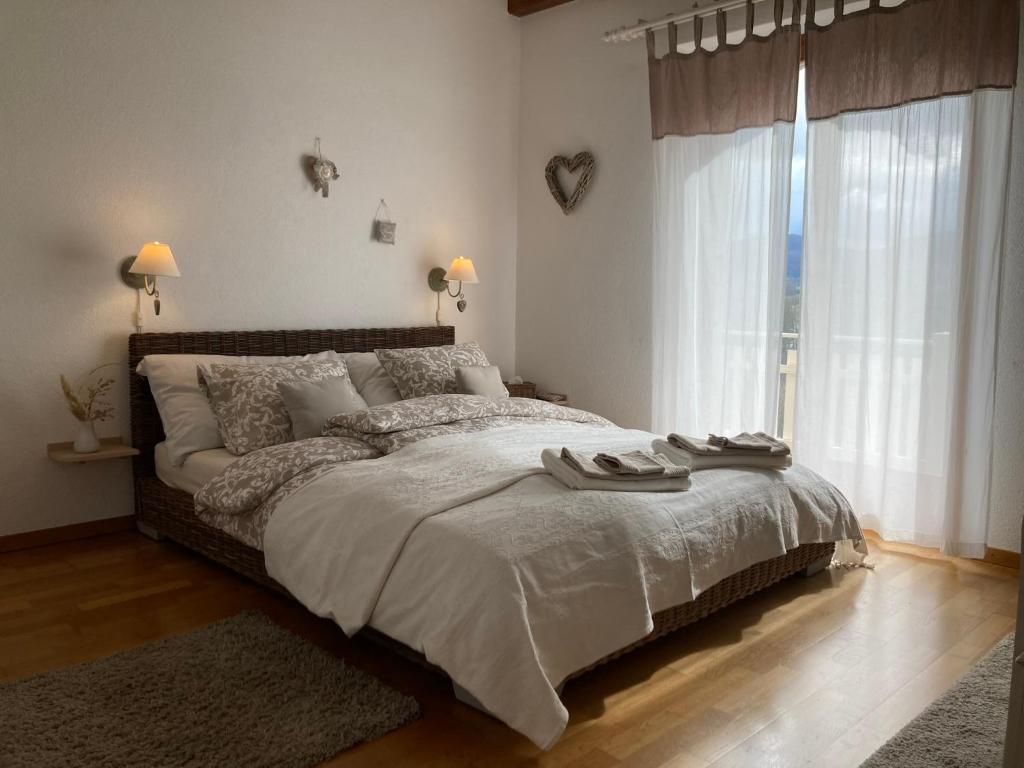 1 dormitorio con cama grande y ventana grande en Escale sur la Côte, en Porrentruy