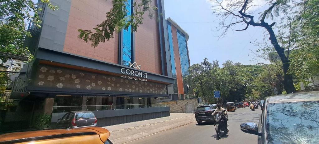 um edifício ao lado de uma rua com carros em Coronet The Boutique Hotel em Pune