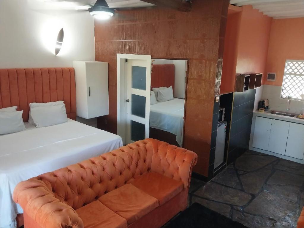 um quarto de hotel com duas camas e um sofá em Sagwe Riviera Diani, Kenya em Diani Beach