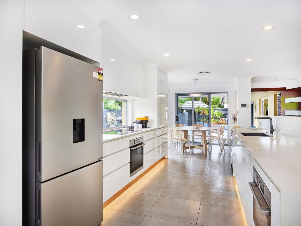 an open kitchen with white cabinets and a table at Luxurious home with pool and Water views in Gold Coast