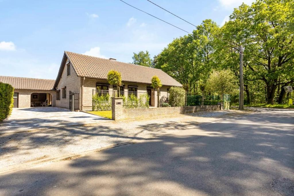 a house on a street with a driveway at Holiday home in the greenery of Limburg in Houthalen-Helchteren