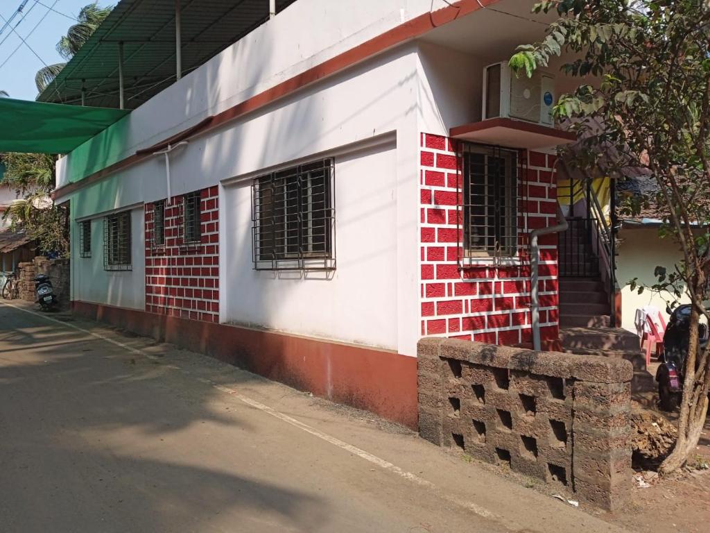 un edificio rosso e bianco con finestre su una strada di Anand Nivas a Malwan