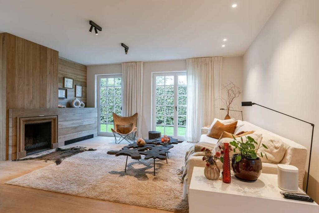 a living room with a couch and a fireplace at Beautifully decorated villa near the city of Knokke in Knokke-Heist