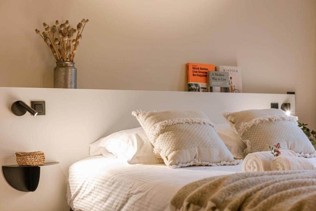 uma cama com lençóis brancos e almofadas em WAY SWEET DREAMS - Room 2 em Gent