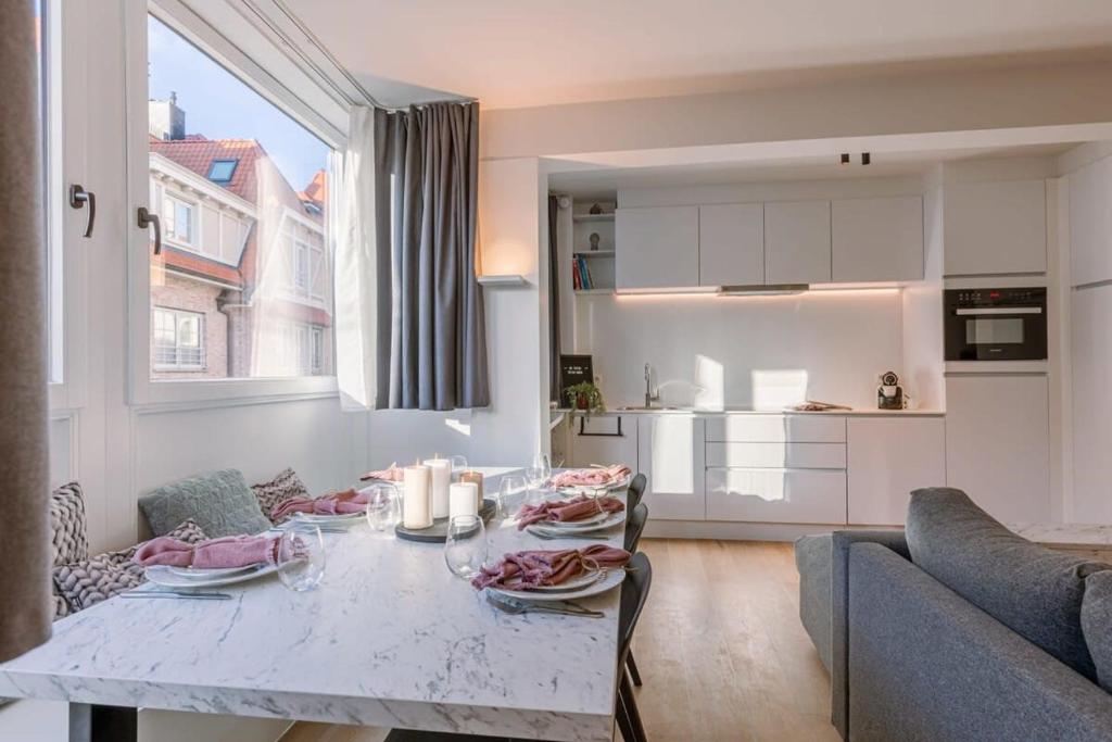een keuken en een woonkamer met een tafel en een bank bij Appartement in 'De Haan' in De Haan