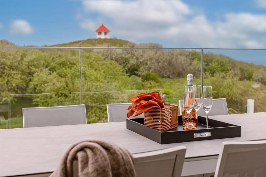 einen Tisch mit einem Korb Weingläser und einer Flasche in der Unterkunft Luxurious penthouse with beautiful sea view and private parking in De Haan