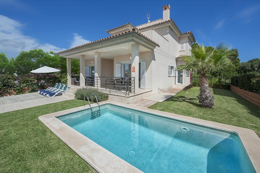 a villa with a swimming pool in front of a house at Villa Marisa II in Alcudia