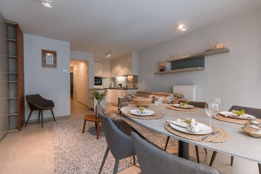 a dining room and living room with a table and chairs at Huswell - Comfortable 2 bedroom apartment with sea-view in Knokke-Heist