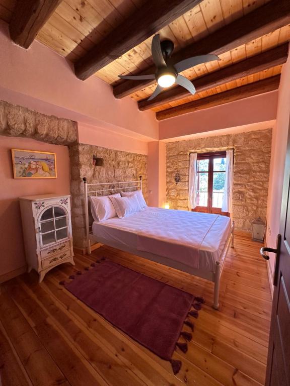 a bedroom with a bed and a ceiling fan at Home · Makrades Corfu in Makrádes