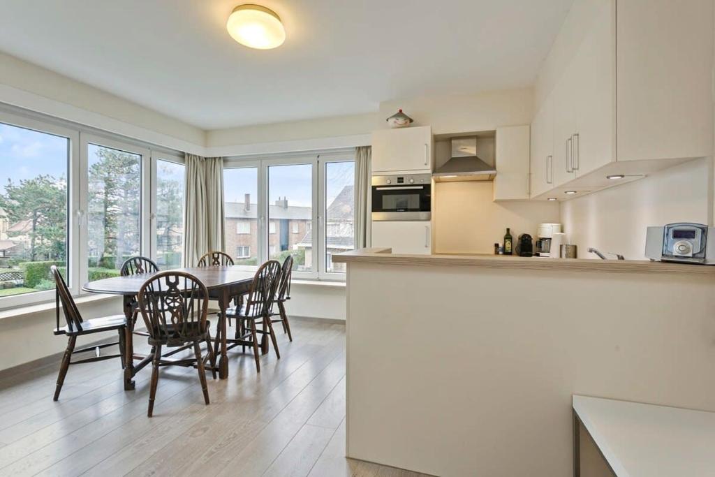 een keuken en eetkamer met een tafel en stoelen bij Lovely Family Apartment 50 meters from the Sea in De Haan