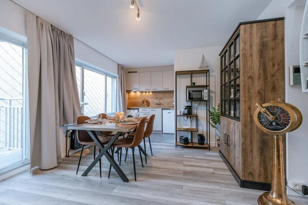 a kitchen and dining room with a table and chairs at Charming studio with terrace nearby the beach in Middelkerke