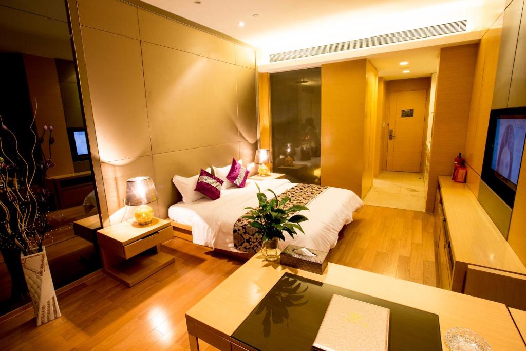 Habitación de hotel con cama y TV en SLD-Yicen INTERNATIONAL SERVICE APARTMENT, en Guangzhou