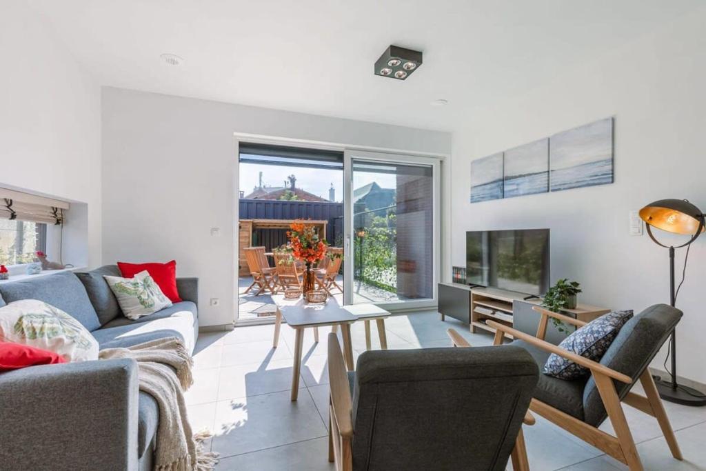 een woonkamer met een bank en een tafel bij Family-Friendly House with sunny terrace and garden in Oostende