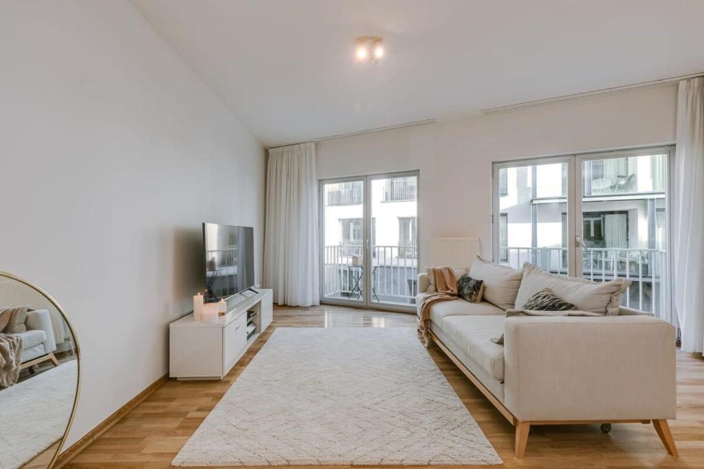 uma sala de estar branca com um sofá e uma televisão em Stylish apartment with terrace and balcony em Antuérpia