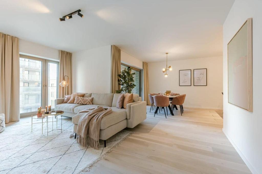 Huswell - Apartment with terrace close to the sea في أوستند: غرفة معيشة بها أريكة وطاولة