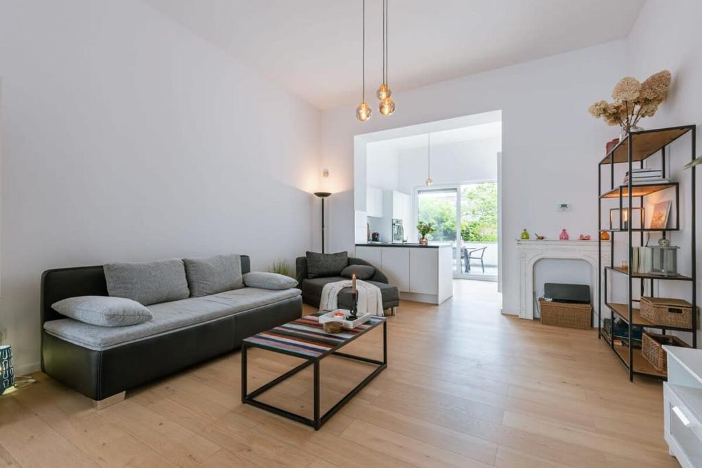 - un salon avec un canapé et une cheminée dans l'établissement Spacious and bright apartment with sunny terrace, à Ostende