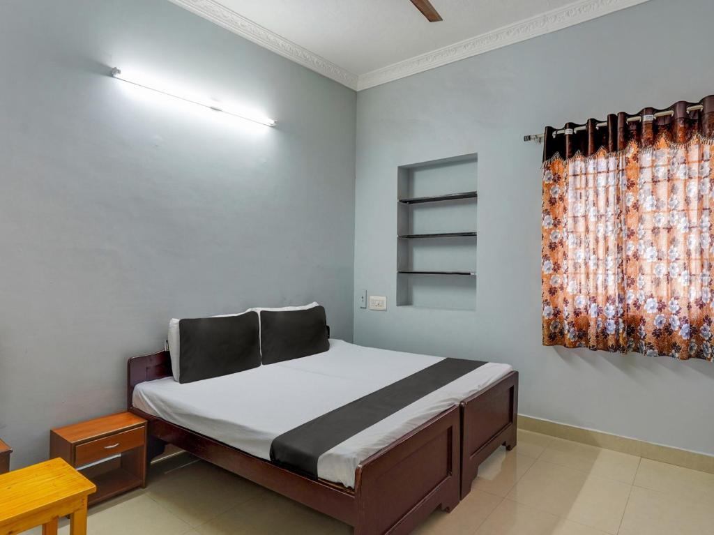 a bedroom with a bed and a window at OYO Blue jay in Chennai