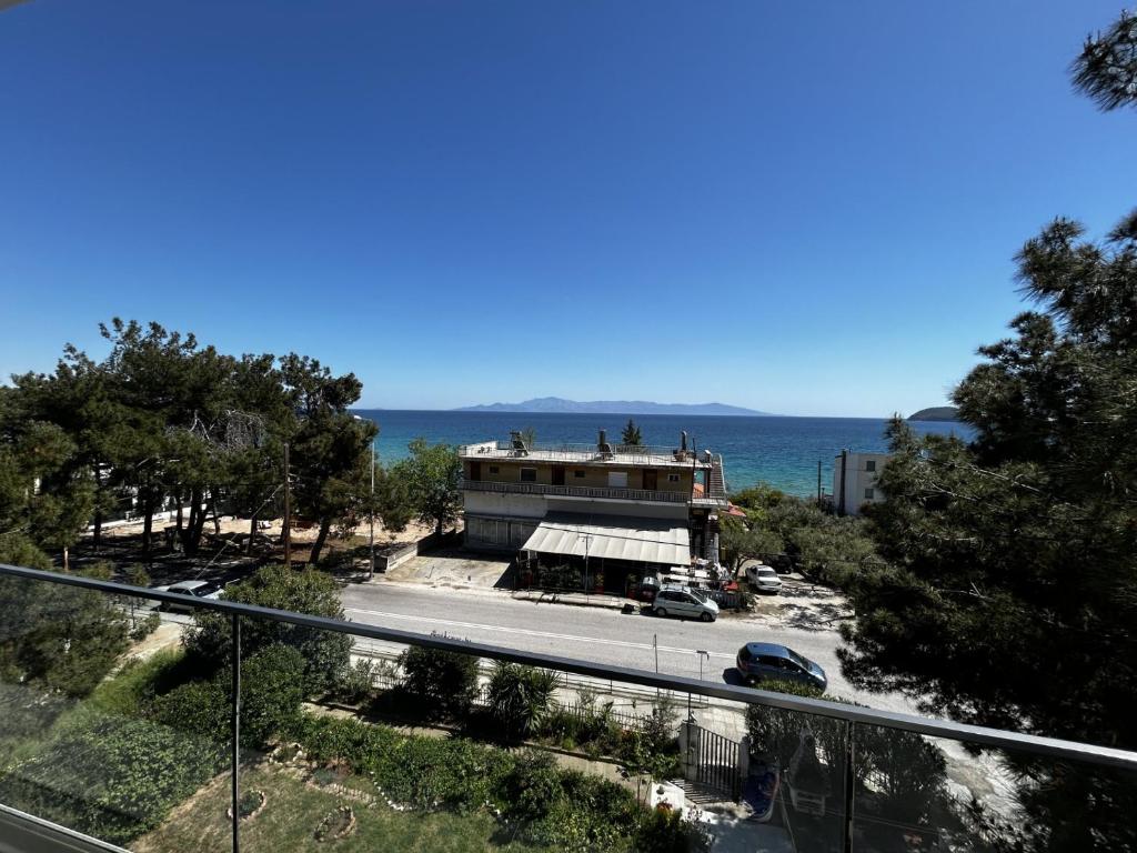 a building on the side of a road next to the ocean at Sunrise and Sunset Palio Sea View Appartment in Kavala