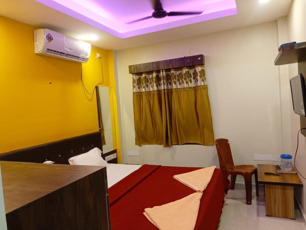 Hotel Jagdish Palace Puri في بوري: غرفة بها سرير ومروحة سقف