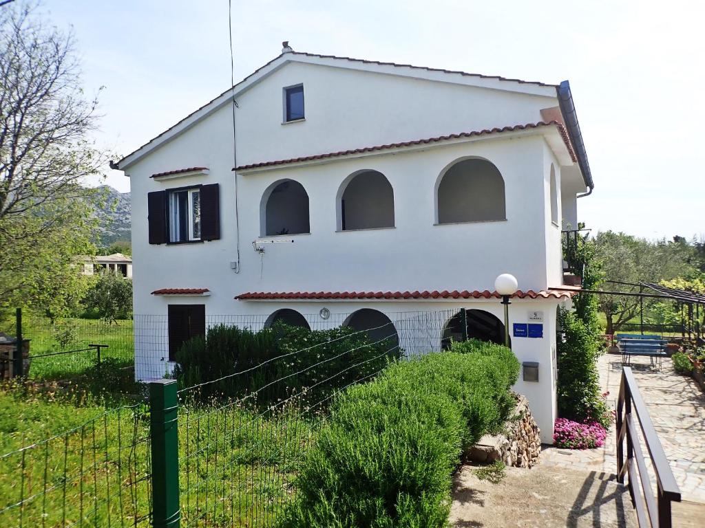 una casa blanca con una valla delante en Apartmani Katica-u blizini plaže "Pisak", en Seline