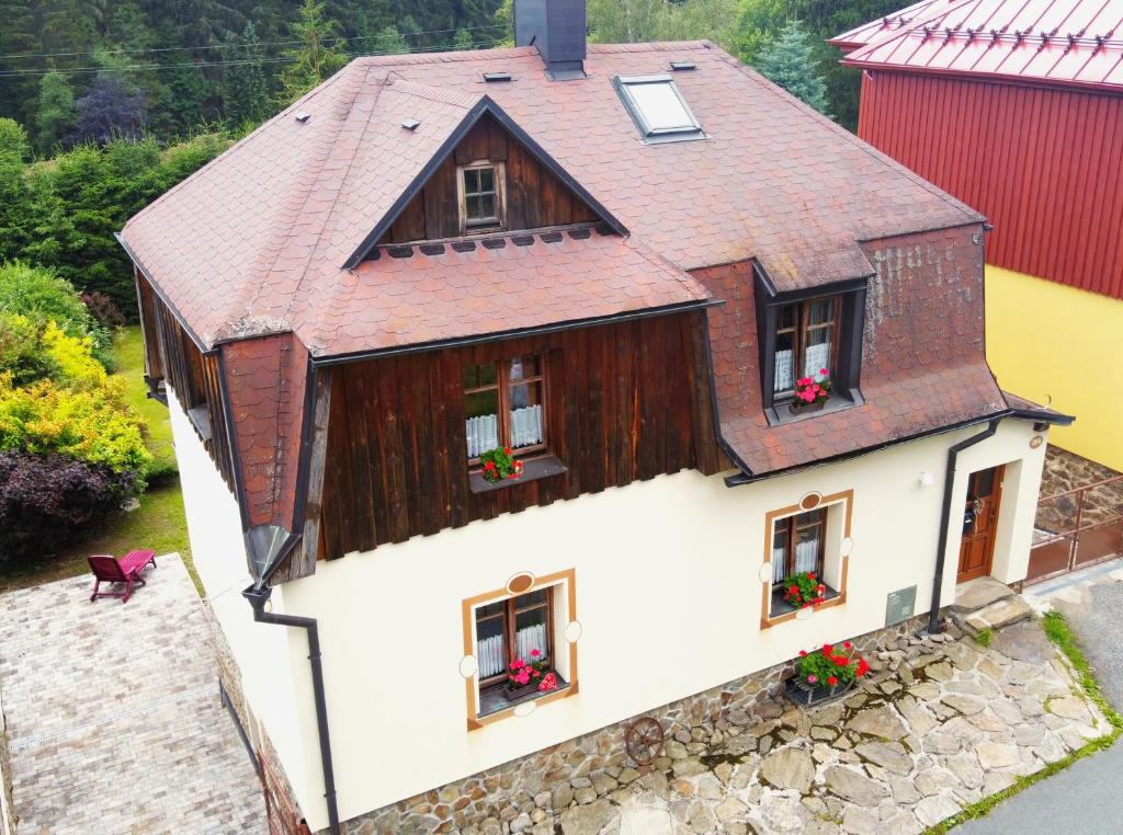 - une vue aérienne sur une maison ornée de fleurs dans les fenêtres dans l'établissement Apartmány Chalupinka, à Železná Ruda