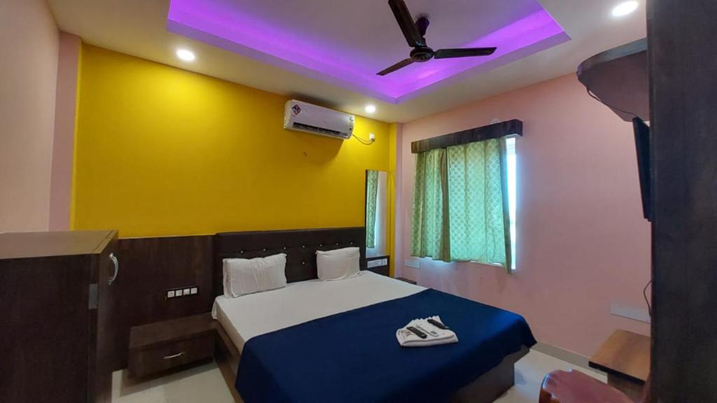 Hotel Jagdish Palace Puri في بوري: غرفة نوم بسرير ومروحة سقف