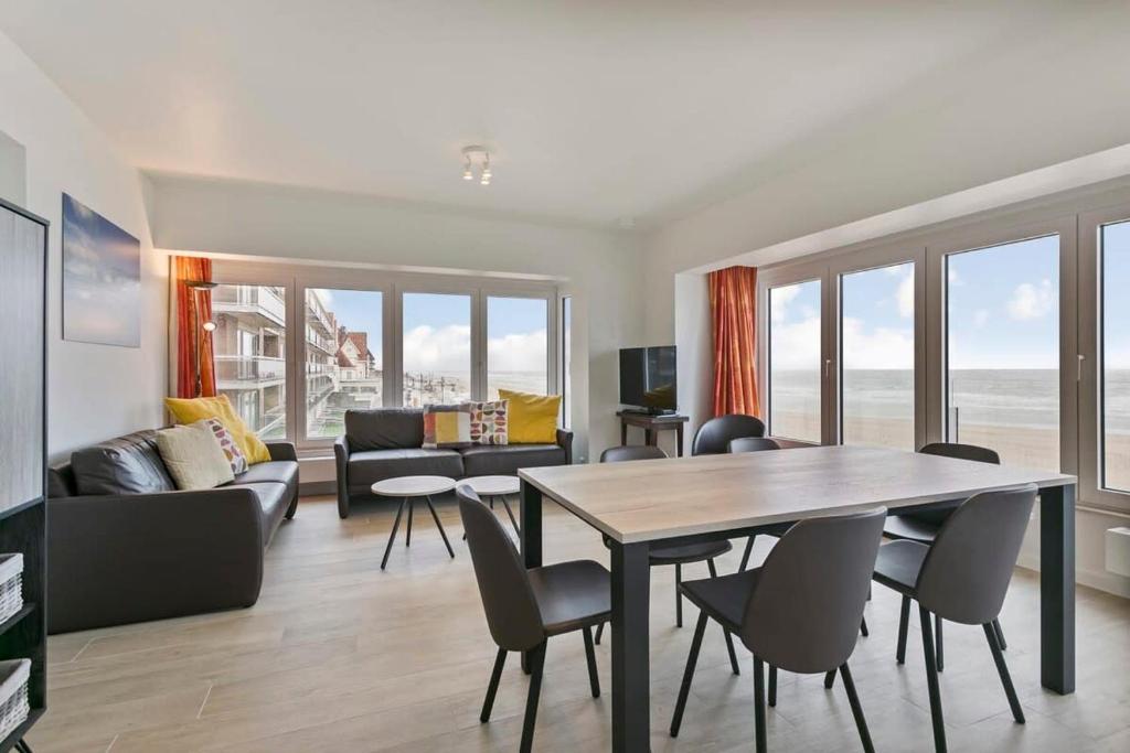 ein Wohnzimmer mit einem Tisch und Stühlen in der Unterkunft Majestic Apartment With Breathtaking Sea View in De Haan