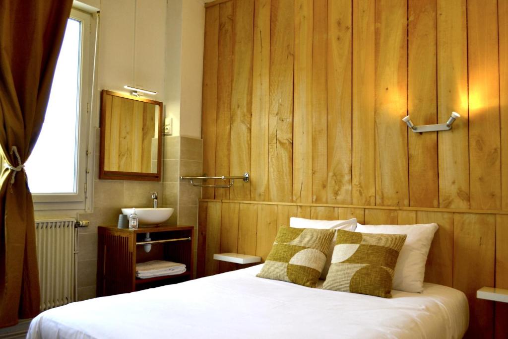 sypialnia z łóżkiem, umywalką i lustrem w obiekcie Hôtel Alizéa w La Rochelle