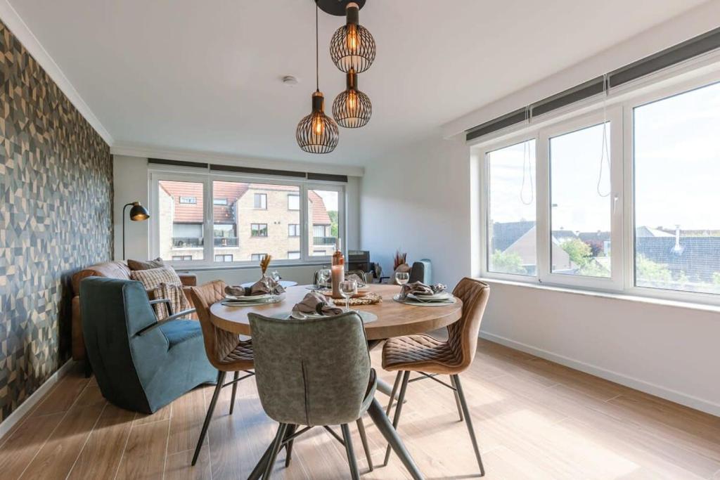 a dining room with a table and chairs and a couch at Cosy apartment with vintage interior in De Haan