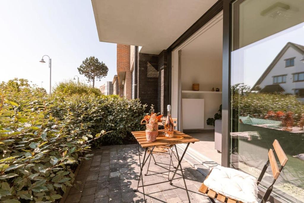 a table on the patio of a house at Luxuriously appointed apartment with lovely terrace and private parking in Blankenberge