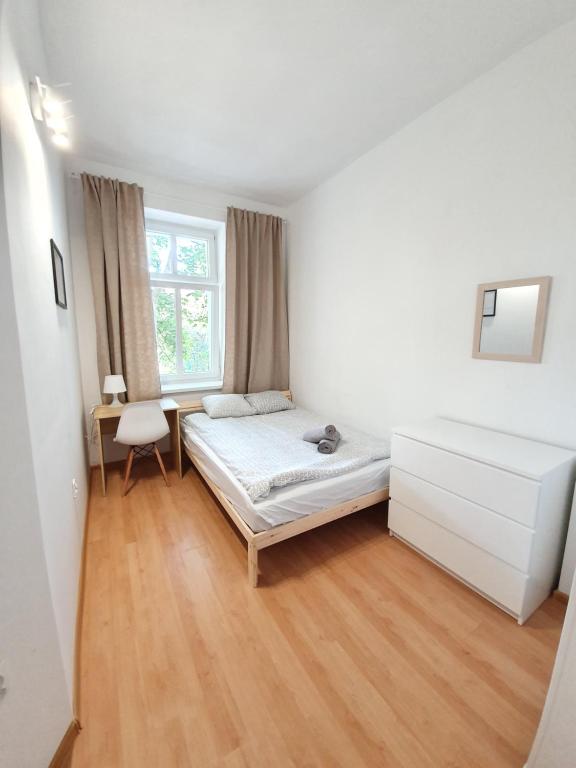 um quarto com uma cama, uma secretária e uma janela em Kwatery Oliwka em Sopot