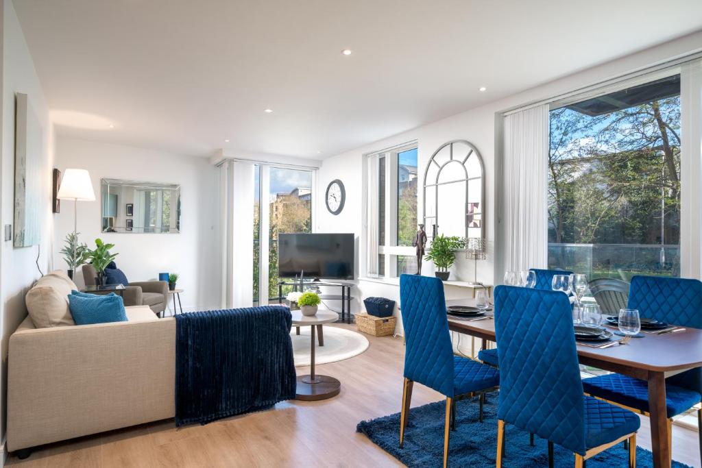 sala de estar con mesa y sillas azules en Lux Kew Bridge 7 guest balcony condo en Kew Bridge