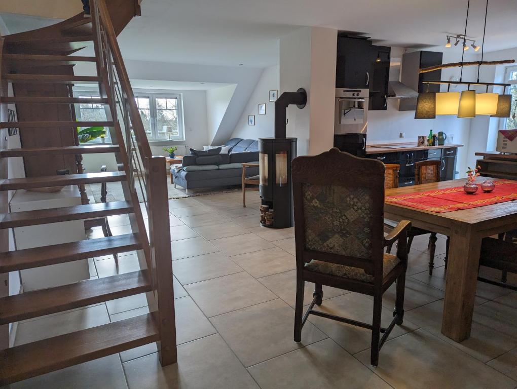 a kitchen and living room with a wooden table and stairs at Landleben Eichenhof in Himbergen