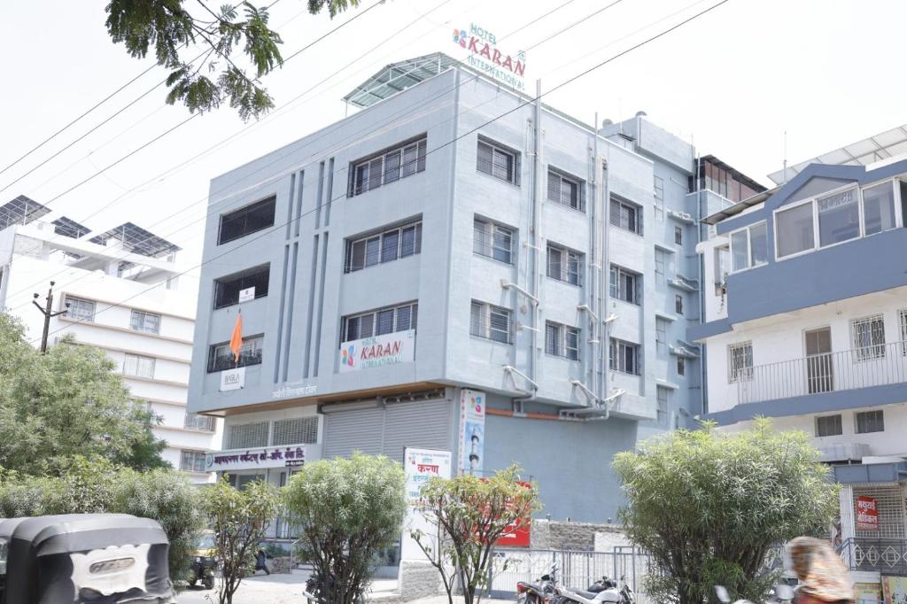 um edifício branco com uma placa em cima em Hotel Karan International ,Aurangabad em Aurangabad