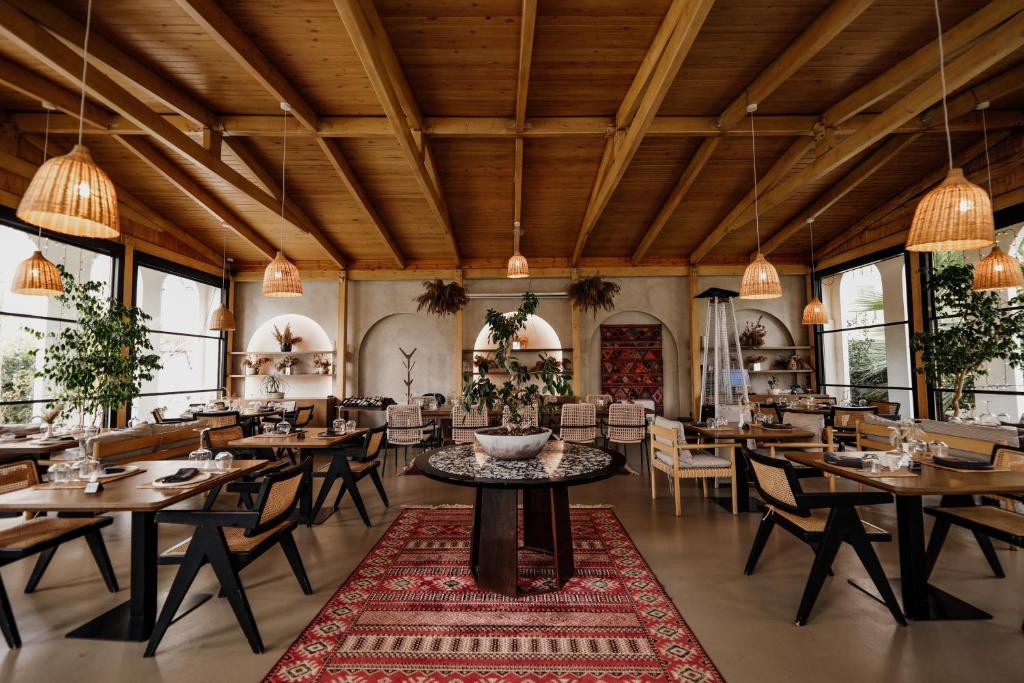 un ristorante con soffitti e tavoli in legno e sedie di Flower Hotels & Resorts a Golem
