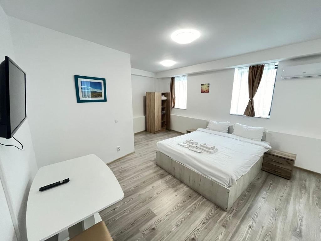 Cette chambre blanche comprend un lit et une télévision. dans l'établissement Boutique Hotel Elena Doamna, à Iaşi