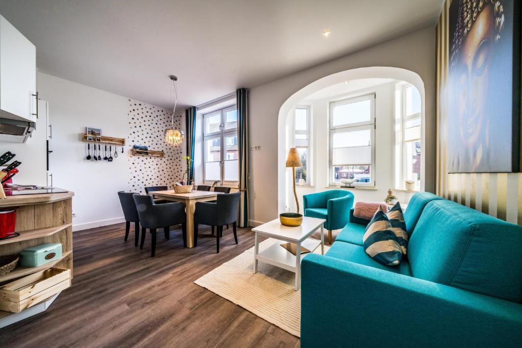 uma sala de estar com um sofá azul e uma mesa em RIAS-Beachvilla-Ocean em Borkum