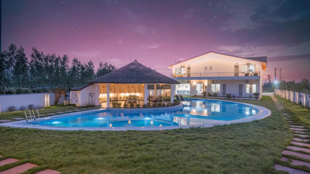 a house with a swimming pool at night at The Exot Prakaram in Rāmnagar