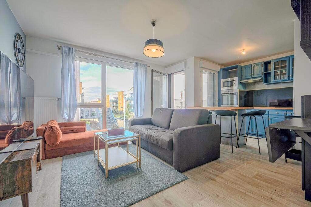 un salon avec un canapé et une table dans l'établissement Appt T3 - 15min de Disneyland - Parking gratuit, à Bussy-Saint-Georges