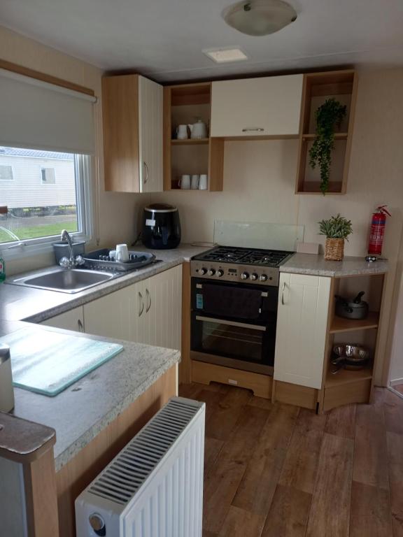a kitchen with a stove and a sink at SANDY BAY STAYOVER in North Seaton