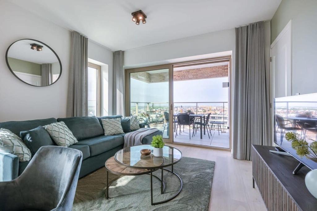 sala de estar con sofá verde y mesa en Apartment with beautiful seaview in Ostend, en Ostende