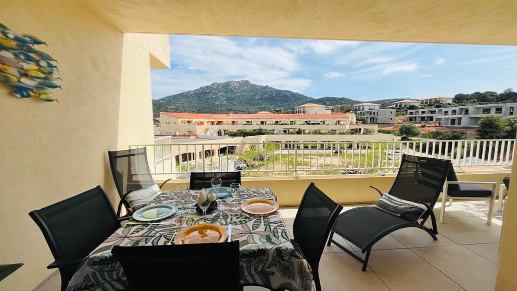 d'une table à manger et de chaises sur un balcon avec vue. dans l'établissement Appartement MARINA 1 LUMIO, à Lumio